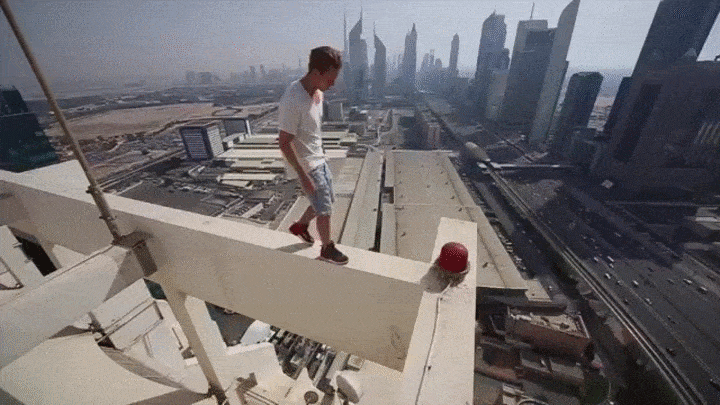Homem praticando parkour no alto de um prédio